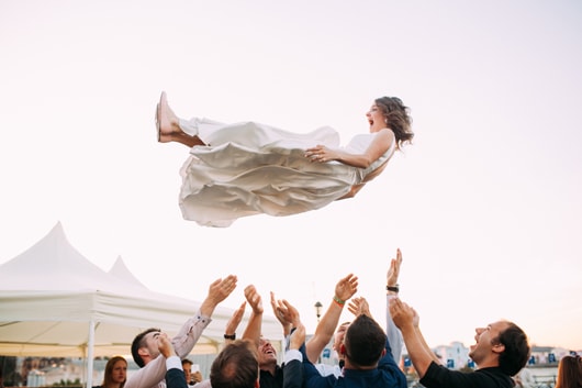 Von Hochzeitsgästen zur Feier des Tages in die Luft geworfene Braut.